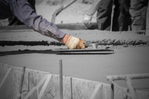 Construction workers leveling concrete pavement.